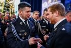 Marszałek Łukasz Smółka dzielący się opłatkiem ze strażakami