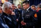 Marszałek Łukasz Smółka dzielący się opłatkiem ze strażakami