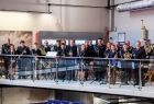 Kilkadziesiąt osób pozujących do wspólnej fotografii w oryginalnych i nowoczesnych przestrzeniach Małopolskiego Muzeum Pożarnictwa w Alwerni