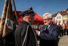 Wicemarszałek Józef Gawron przypina odznaczenie do marynarki strażaka.