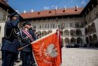 Funkcjonariusz prezentujący sztandar z białym orłem oraz słowami Ojczyzna i prawo