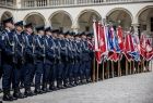 Policjanci prezentujący broń oraz poczty sztandarowe na dziedzińcu Zamku Królewskiego