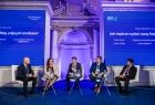 Grupa osób siedząca na scenie.