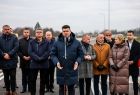 Marszałek Łukasz Smółka przy mikrofonie. W tle grupa osób.