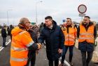Marszałek Łukasz Smółka wita się z mężczyzną w pomarańczowej kamizelce.