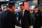 Uścisk dłoni i gratulacje. Wicemarszałek Łukasz Smółka podczas rozmowy ze strażakiem