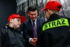 Wicemarszałek Łukasz Smółka podczas rozmowy z dwoma chłopcami z młodzieżowej drużyny pożarniczej