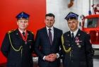 Wicemarszałek Łukasz Smółka oraz dwóch strażaków w galowych mundurach