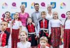 Iwona Gibas z zarządu województwa oraz burmistrz Wolbromia Radosław Kuś wraz z grupą dzieci w strojach ludowych