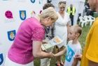 Iwona Gibas z zarządu województwa gratuluje wyniku i wręcza dyplom chłopcu 