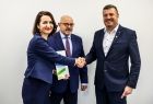 Członek zarządu Marta Malec-Lech w geście uścisku dłoni z mężczyzną w garniturze. 