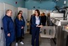 Członek zarządu Marta Malec-Lech z grupą osób w pomieszczeniu pralni.