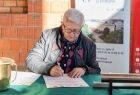 Radny Stanisław Pasoń podpisujący dokument.