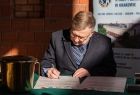 Wicemarszałek Witold Kozłowski podpisujący dokument.