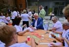 Wicemarszałek Józef Gawron siedzący przy stoliku z grupą kobiet.