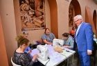 Wicemarszałek Józef Gawron przy stoliku z maszynami do szycia.