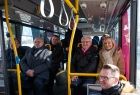 Samorządowcy siedzący wewnątrz autobusu.