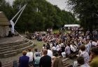 ludzie siedzący w amfiteatrze spoglądający na scenę