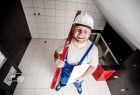 Uśmiechnięty robotnik trzyma w ręku czerwoną poziomicę.