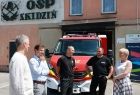 Iwona Gibas z zarządu województwa podczas rozmowy z samorządowcami i strażakami ochotnikami. W tle wóz strażacki i remiza OSP Skidziń
