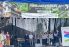 Konferansjerzy w strojach ludowych oraz przedstawiciele urzędów i instytucji na scenie Podhalańskiej Wystawy Zwierząt Hodowlanych w Ludźmierzu. W tle okolicznościowe puchary i statuetki dla nagrodzonych hodowców