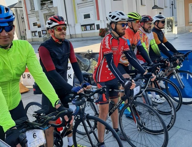 Kolarze na rowerach stoją na rynku w Wadowicach.