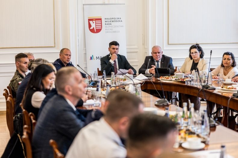 Marszałek Łukasz Smółka i wicemarszałek Ryszard Pagacz siedzą przy stole. Obok siedzą inni ludzi.,