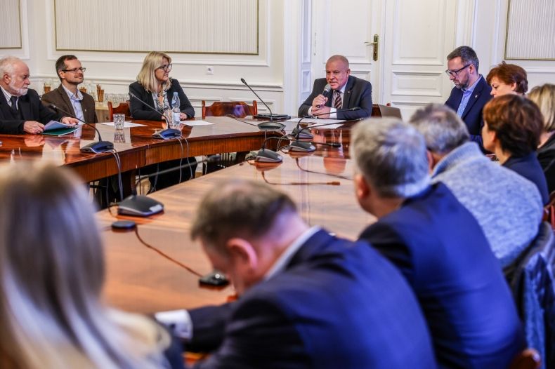Uczestnicy spotkania siedzą przy stole.