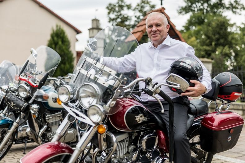 Wicemarszałek Ryszard Pagacz siedzi na motocyklu, w ręce trzyma kask.