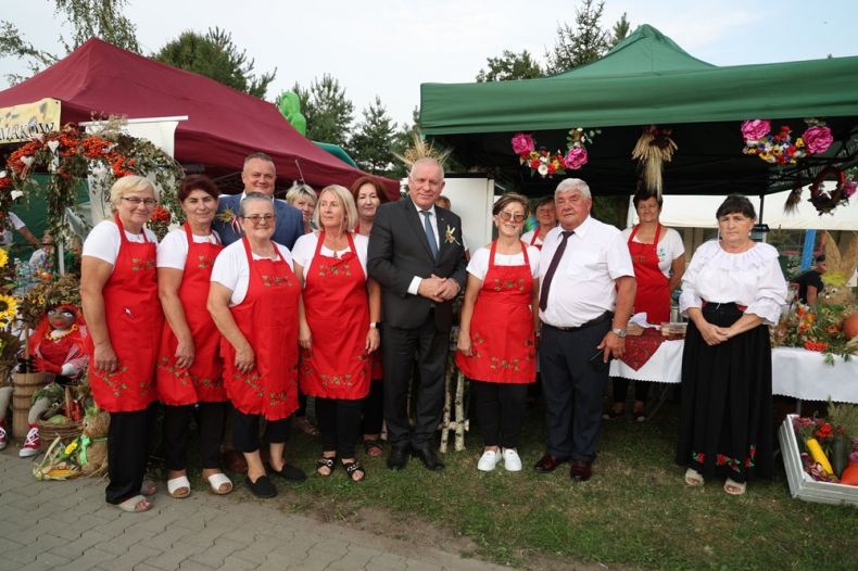 Wicemarszałek Ryszard Pagacz stoi z ludźmi w strojach ludowych.