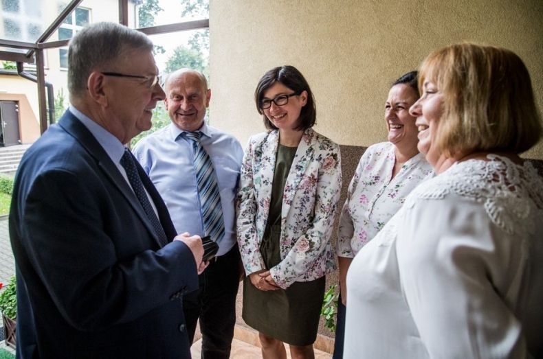 Wicemarszałek Witold Kozłowski rozmawia z ludźmi na korytarzu szkoły.