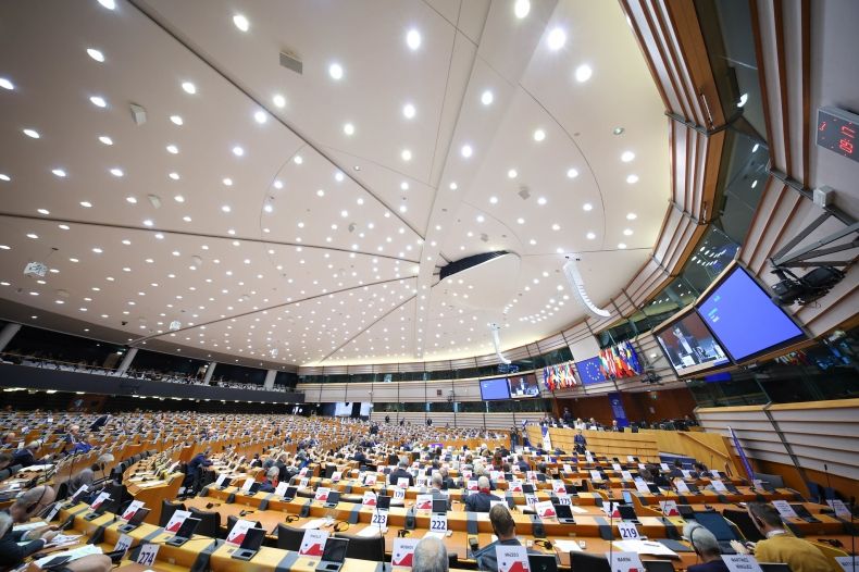 Ludzie zebrani na sali plenarnej Parlamentu Europejskiego. 