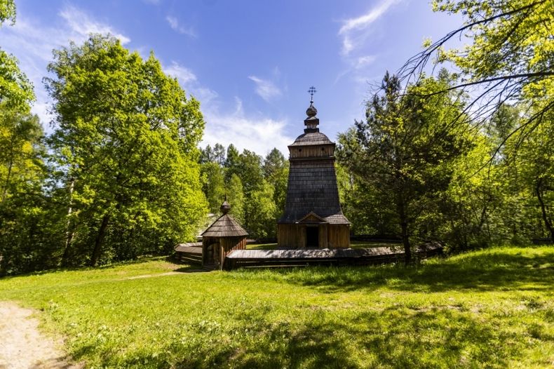 Drewniany budynek kościoła otoczony zielenią