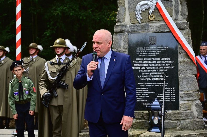 Wicemarszałek Ryszard Pagacz stoi przed pomnikiem.