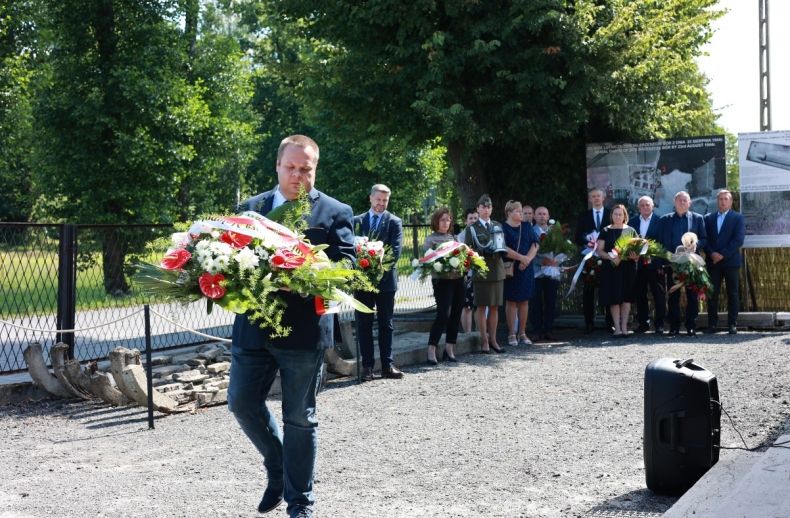 Jakub Przewoźnik z agendy zamiejscowej Urzędu Marszałkowskiego w Oświęcimiu składa wieniec w imieniu Zarządu Województwa Małopolskiego przed tablicą historycznego budynku w Brzeszczach Borze 