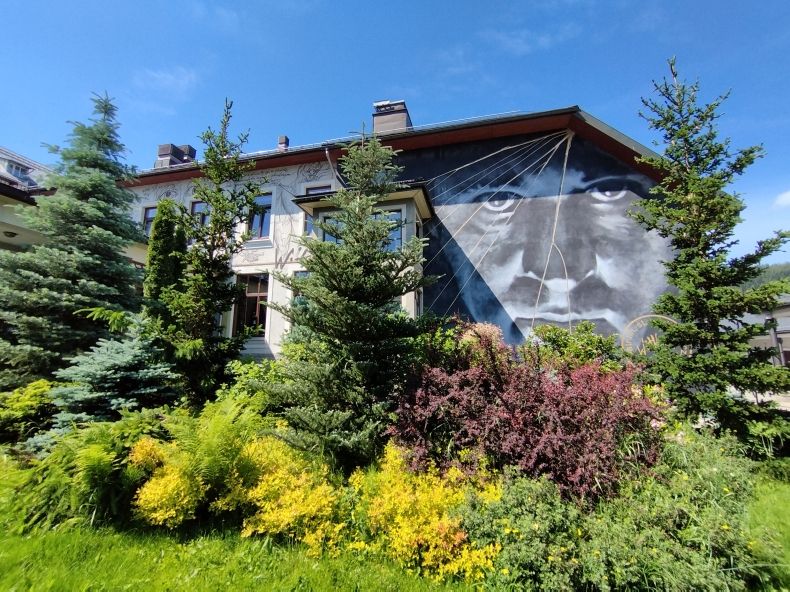 budynek teatru od strony Sceny Witkacego. Na ścianie mural z portretem Witkacego przed nim bujna roślinność.