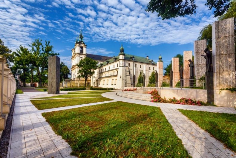 Klasztor na Skałce w Krakowie. Na pierwszym planie widoczna zieleń i betonowe alejki.