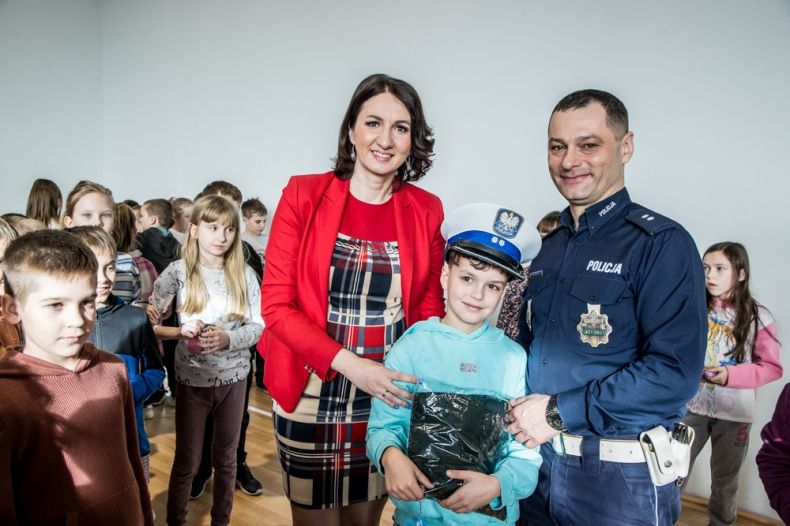 Marta Malec-Lech z zarządu województwa z policjantem i dziećmi.