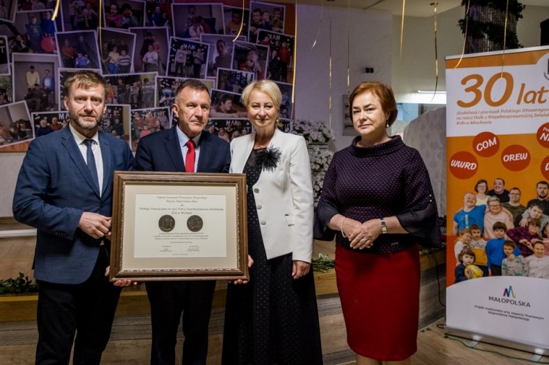 Iwona Gibas z zarządu województwa, radni Lidia Gądek i Mirosław Dróżdż oraz Stanisław Ryłko, przewodniczący Zarządu PSONI w Miechowie prezentują wspólnie Nagrodę Samorządu Województwa Małopolskiego Brązowy Medal Polonia Minor
