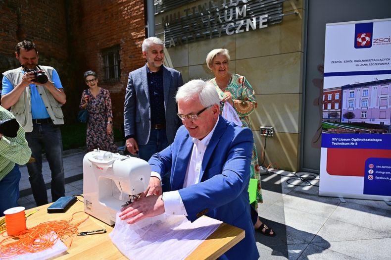 Wicemarszałek Józef Gawron przy maszynie do szycia.