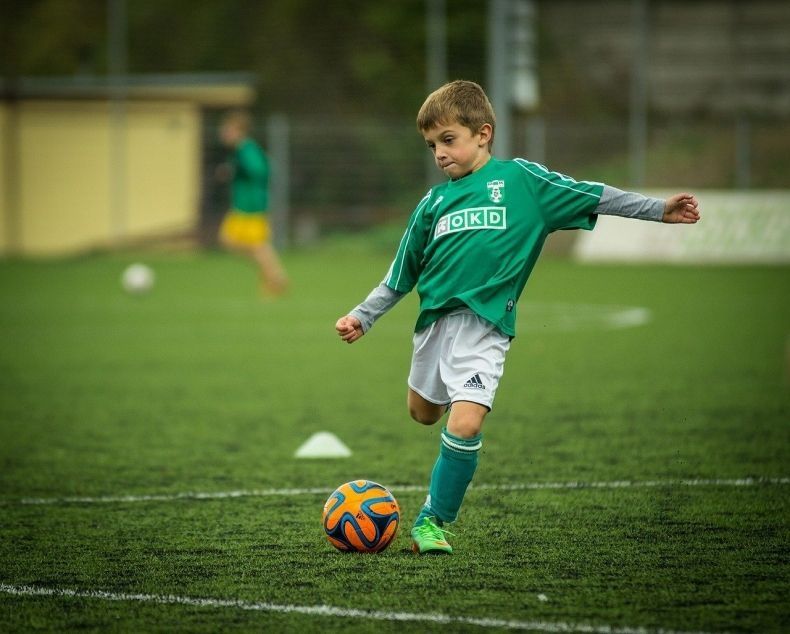 Mały piłkarz na boisku.
