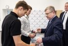 Wicemarszałek Witold Kozłowski rozdaje prezenty dwóm chłopcom.