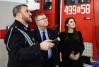 Strażak demonstruje wicemarszałkowi Witoldowi Kozłowskiemu sprzęt. Obok kobieta.
