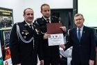 Dwóch strażaków i wicemarszałek Witold Kozłowski z aktem przekazania sprzętu. 