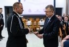 Wicemarszałek Witold Kozłowski przekazuje akt strażakowi. 