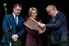 Samorządowcy wręczający okolicznościowe dyplomy i statuetki 