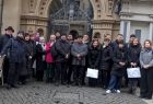 Ludzie stoją przed zabytkową bramą.