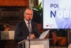 Prezes stowarzyszenia stoi przy mównicy.