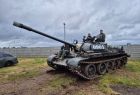 Czołg T-55 jedzie po łące.