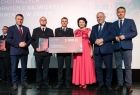 Wicemarszałek Ryszard Pagacz stoi z beneficjantami.